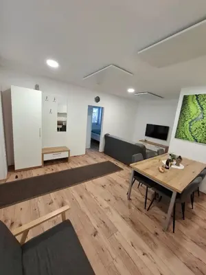 a living room with a table and a couch at Apartma Pohorc - Macesen in Pohorje