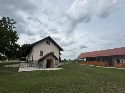 a house with a grass yard next to a building at Apartments LESKOVAR in Ormoz
