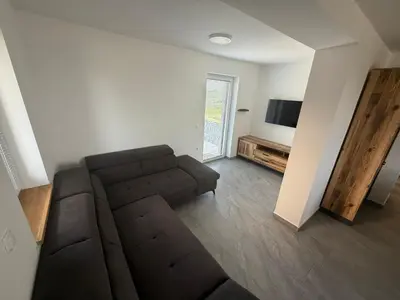 a living room with a couch and a flat screen tv at Apartments LESKOVAR in Ormoz
