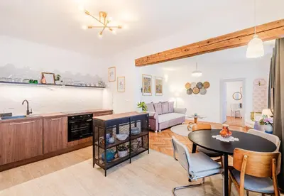 a kitchen and a living room with a table and a couch at Apartment Vandora in Idrija