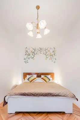 a bedroom with a bed with a chandelier at Apartment Vandora in Idrija