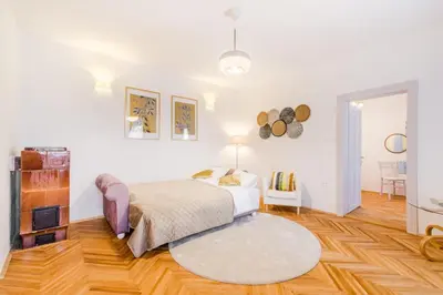 a white bedroom with a bed and a rug at Apartment Vandora in Idrija