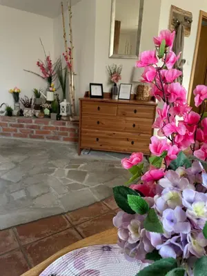 a vase filled with pink flowers on top of a table at Wellness soba Skriti raj Banovci in Banovci