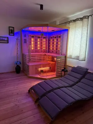 a bedroom with a large bed and a fireplace at Wellness soba Skriti raj Banovci in Banovci
