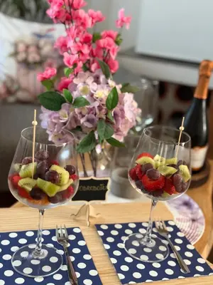 two wine glasses filled with fruit on a table at Wellness soba Skriti raj Banovci in Banovci