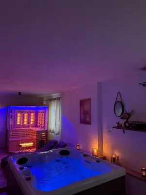 a large bath tub in a room with purple lighting at Wellness soba Skriti raj Banovci in Banovci