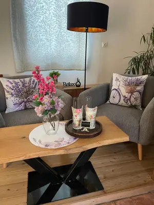 a living room with a coffee table with flowers on it at Wellness soba Skriti raj Banovci in Banovci