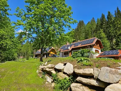 a house with solar panels on the roof at Authentic Pohorje house with riverside outdoor sauna in Oplotnica