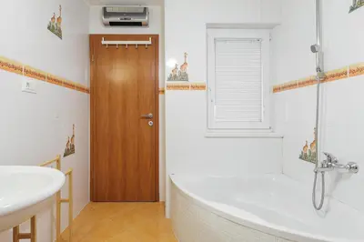 a bathroom with a bath tub and a sink at Apartment Mandi By DIMBIKES in Ajdovščina