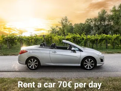 a silver convertible car parked on a road with the words rent a car per at Apartment Mandi By DIMBIKES in Ajdovščina