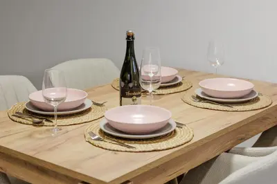 a table with a bottle of wine and plates and glasses at Apartment Mandi By DIMBIKES in Ajdovščina