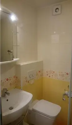 a bathroom with a white toilet and a sink at Colorful City Center Apartment - Parking Available in Ljubljana