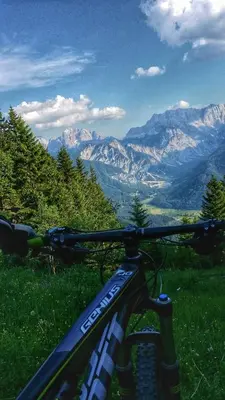 a bike parked on a hill with mountains in the background at GOLOB Apartment Kranjska Gora in Kranjska Gora