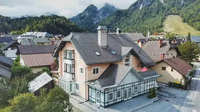 an aerial view of a house with mountains in the background at GOLOB Apartment Kranjska Gora in Kranjska Gora