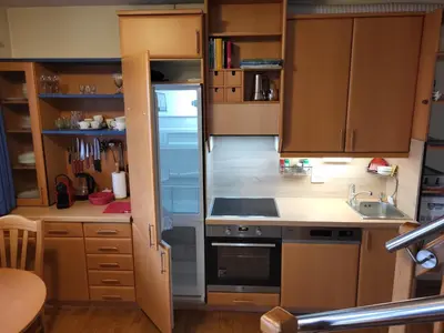 a kitchen with wooden cabinets and a sink and a refrigerator at Apartment Alpine Lake in Bled