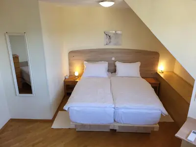 a bedroom with a large white bed with two pillows at Apartment Alpine Lake in Bled