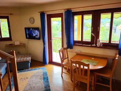 a living room with a table and chairs and windows at Apartment Alpine Lake in Bled