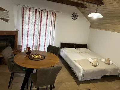a bedroom with a table and a bed and a table and chairs at Apartma Zidanca Bele in Dolenjske Toplice
