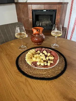 a plate of food on a table with two glasses of wine at Apartma Zidanca Bele in Dolenjske Toplice