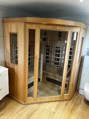 a wooden cabinet with glass doors in a bathroom at Apartma Zidanca Bele in Dolenjske Toplice