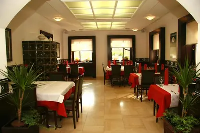 a restaurant with tables and chairs with red and white tablecloths at Gostilna Žolnir in Kostanjevica na Krki