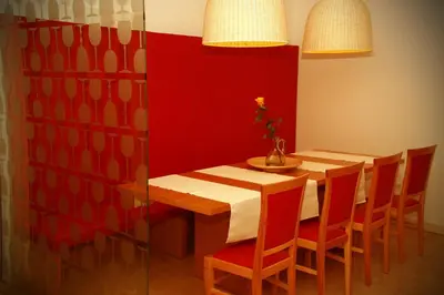 a dining room with a wooden table and red wall at Gostilna Žolnir in Kostanjevica na Krki
