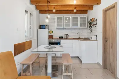 a kitchen with white cabinets and a white table at Relax Bovec in Bovec