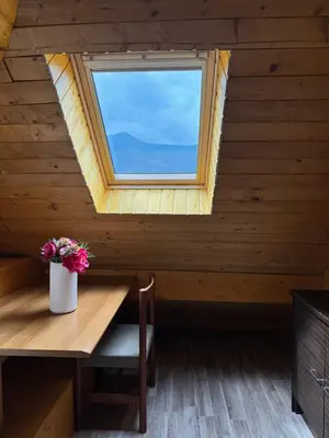 a room with a wooden table and a window at Relax Bovec in Bovec