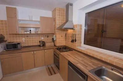 a kitchen with wooden cabinets and a sink and a window at Relax Bovec in Bovec
