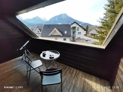 a balcony with a table and chairs and a large window at Planica Studio in Kranjska Gora in Kranjska Gora