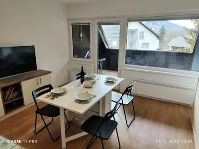 a white table and chairs in a room with a window at Planica Studio in Kranjska Gora in Kranjska Gora