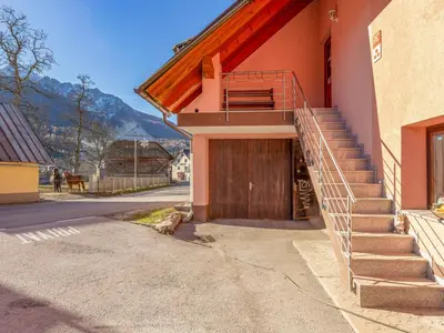a building with a wooden door and stairs on it at Apartment Pr' Kavač by Interhome in Rateče