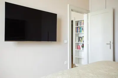 a bedroom with a flat screen tv on a wall at Skyscraper Amazing Castle & City View Apartment in Ljubljana