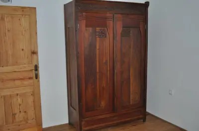 a wooden cabinet in a room next to a door at Apartments Koptur in Škocjan