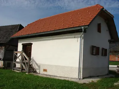 a large white garage with a red roof at Apartments Koptur in Škocjan