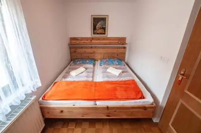 a bed in a small room with a wooden frame at Green Garden Apartments Soklič in Bohinj