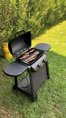a bbq grill sitting on top of the grass at Green Garden Apartments Soklič in Bohinj