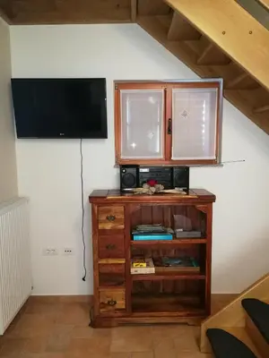 a living room with a tv and a wooden cabinet at Hiša Kranjc in Kobarid