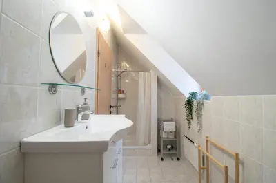 a white bathroom with a sink and a mirror at Chalet Fisherman's Cottage in Bohinj