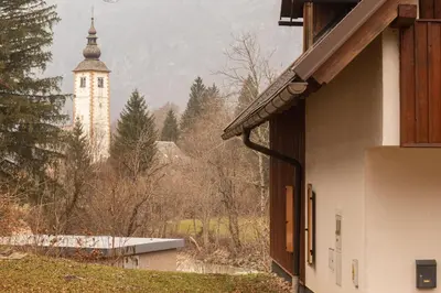 a building with a clock tower in the background at Chalet Fisherman's Cottage in Bohinj