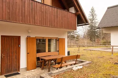 a wooden bench sitting outside of a house at Chalet Fisherman's Cottage in Bohinj