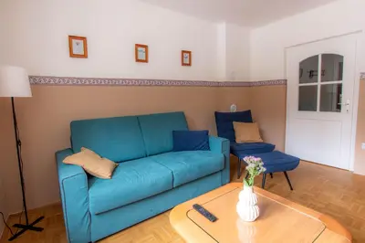 a living room with a blue couch and a table at Apartma Rogla Relax in Oplotnica