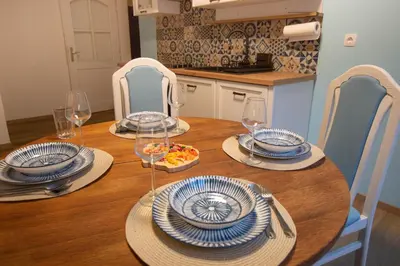 a wooden table with plates and wine glasses on it at Apartma Rogla Relax in Oplotnica