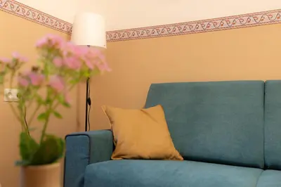 a blue couch with a pillow next to a lamp at Apartma Rogla Relax in Oplotnica