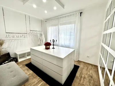 a white room with a dresser and a window at Spacious Cosy Apt with Pool and Parking in Pesnica pri Mariboru