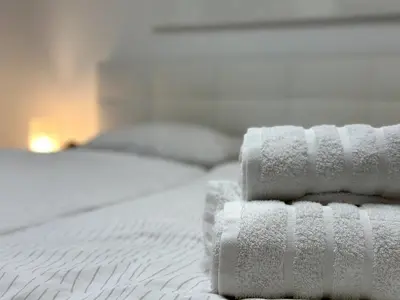 a stack of towels sitting on top of a bed at Spacious Cosy Apt with Pool and Parking in Pesnica pri Mariboru