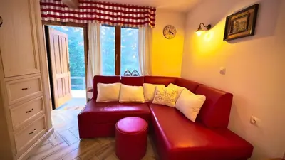 a red couch in a room with a window at Studio Queen Alpine in Cerklje na Gorenjskem