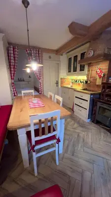 a kitchen with a wooden table and chairs in it at Studio Queen Alpine in Cerklje na Gorenjskem