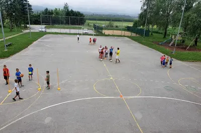 a group of children playing on a basketball court at Weiss Sport & Relax Apartment in Rečica ob Savinji