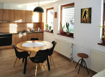 a kitchen with a wooden table and chairs at Weiss Sport & Relax Apartment in Rečica ob Savinji